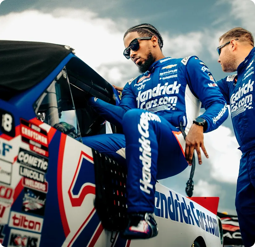 Rajah Caruth beside his race truck in an official website photograph