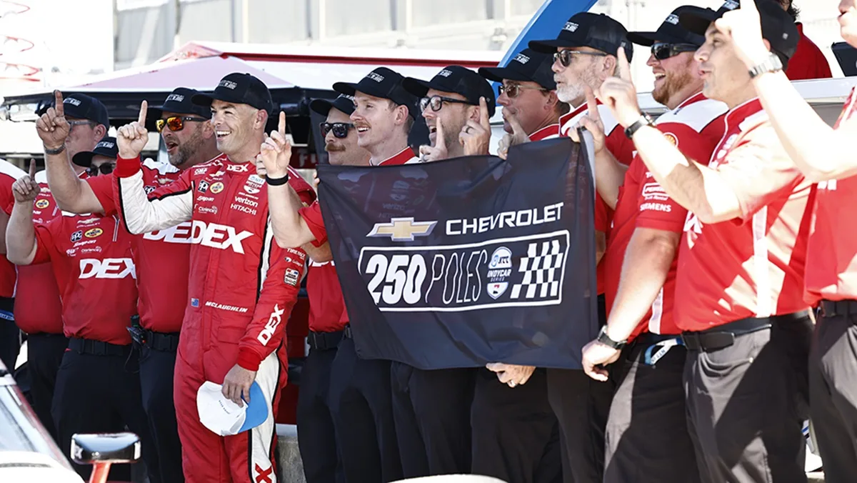 Scott McLaughlin and Team Penske crew celebrating with a Chevrolet banner